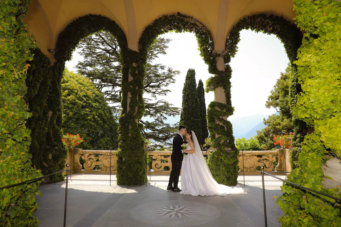 Bride and groom at Villa del Balbianello overlooking Lake Como, luxury wedding venue with historic gardens and panoramic views.
