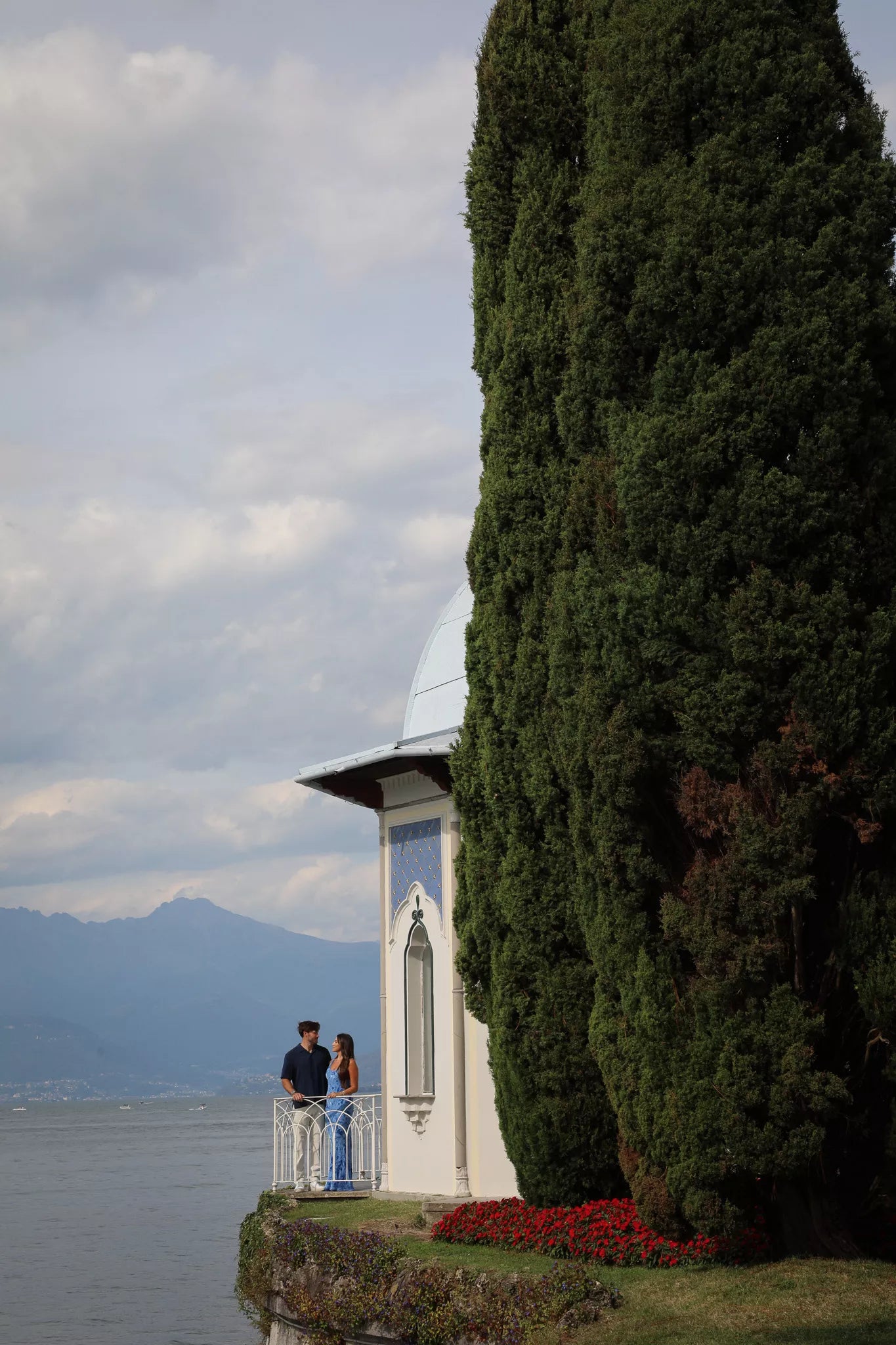 Romantic portrait of a couple on the balcony of the lakeside pavilion at Villa Melzi overlooking Lake Como in Bellagio