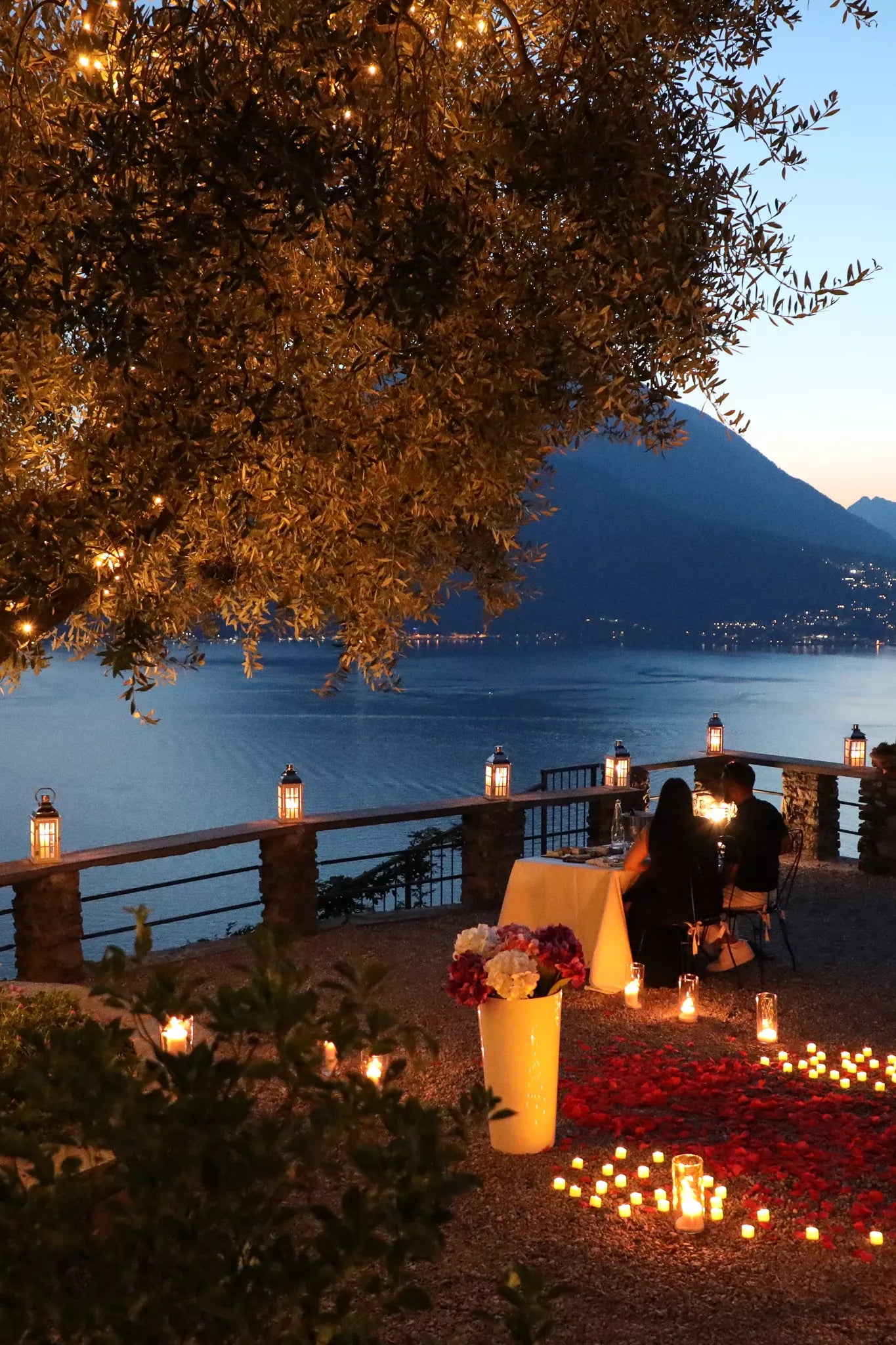 Candlelit Castello di Vezio proposal setup with flowers and panoramic Lake Como view