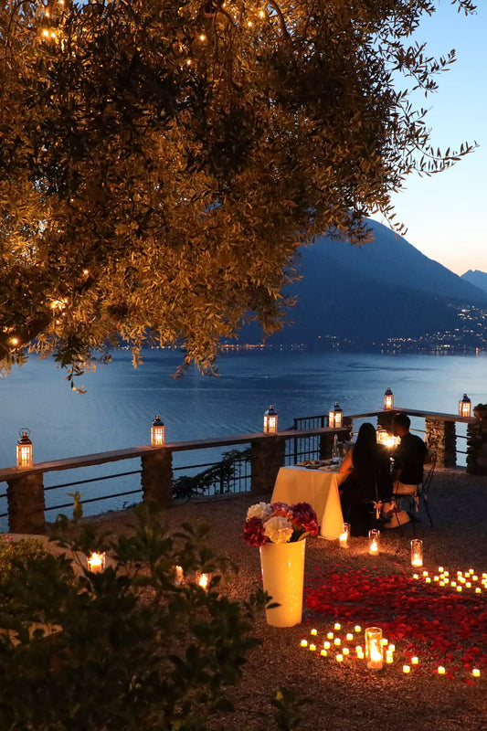 Candlelit Castello di Vezio proposal setup with flowers and panoramic Lake Como view