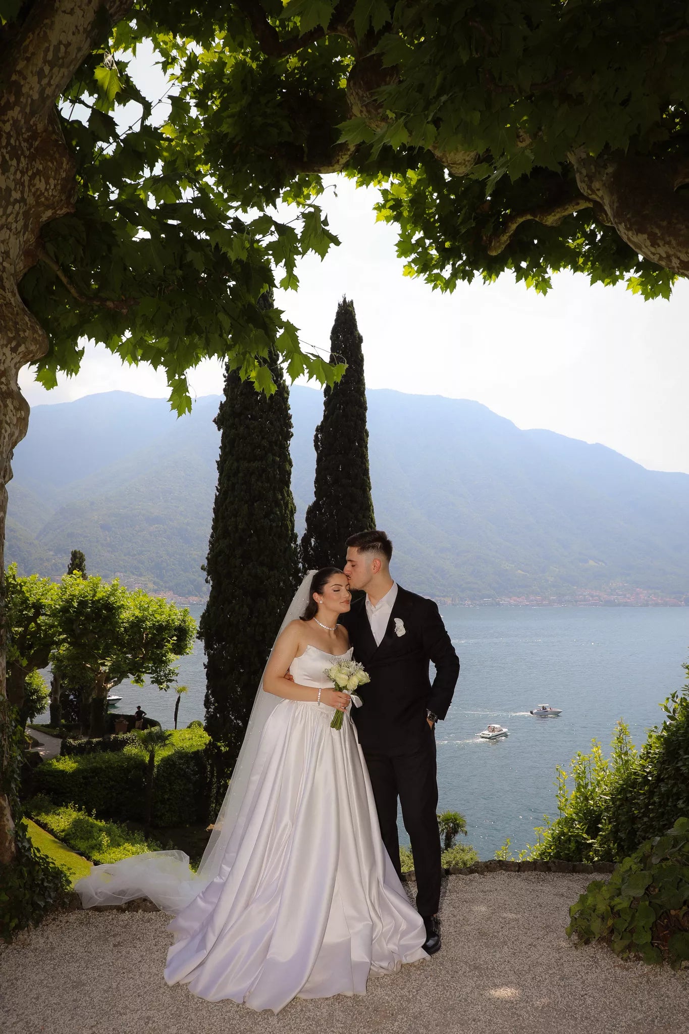 Romantic bride and groom portrait at a scenic Lake Como viewpoint near Villa del Balbianello surrounded by trees