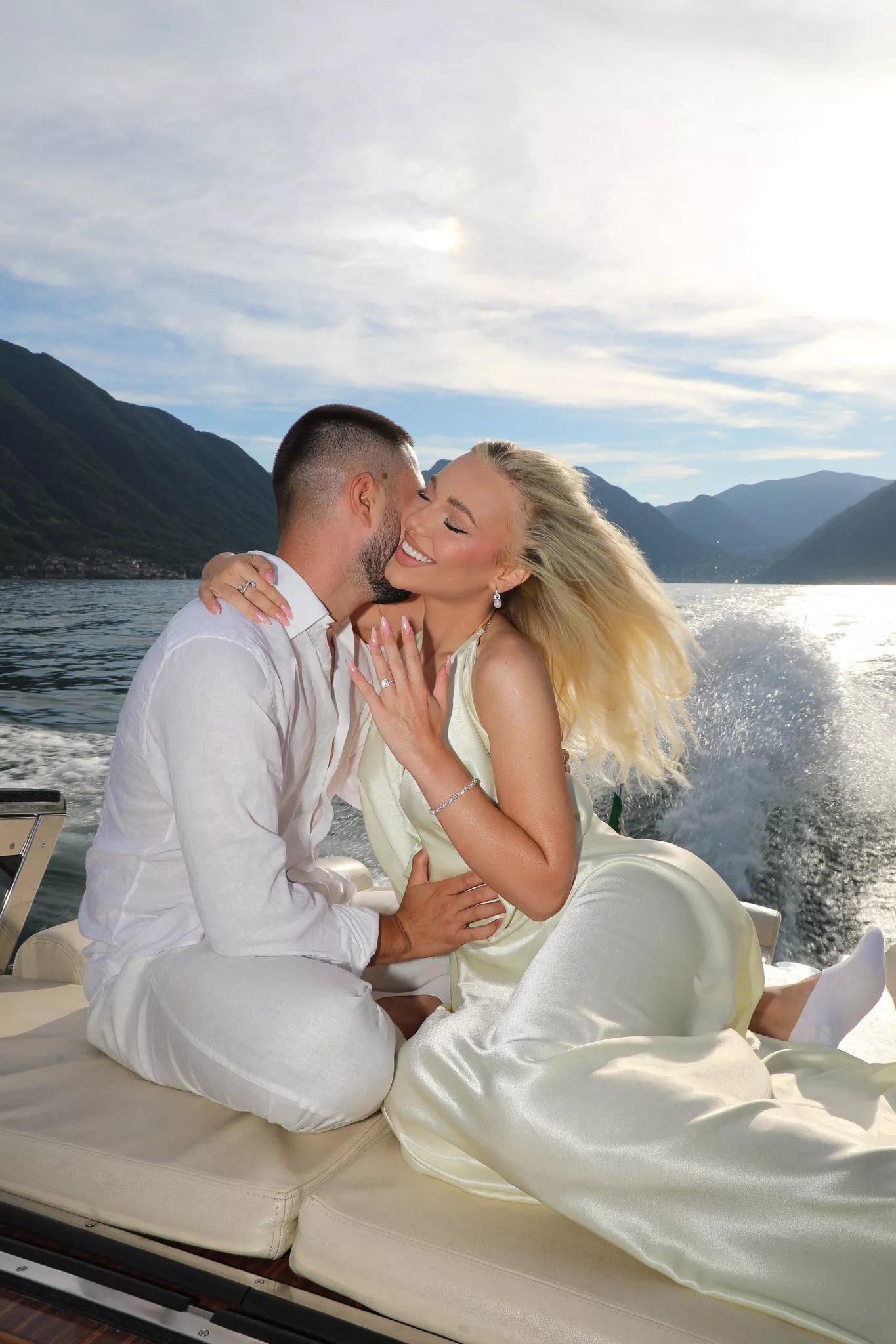 Newly engaged couple celebrating on a fast boat ride across Lake Como at sunset