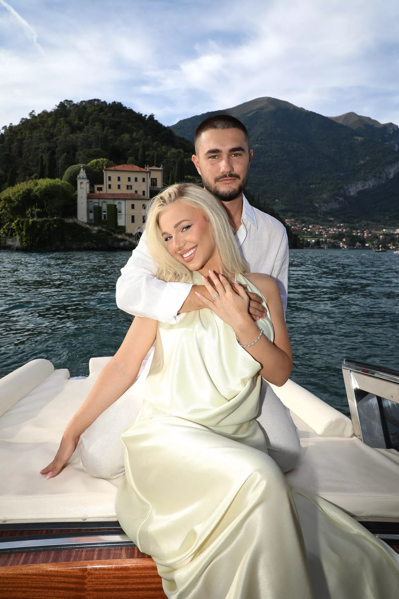 Engagement portraits on a private boat on Lake Como at sunset with a couple embracing in golden light