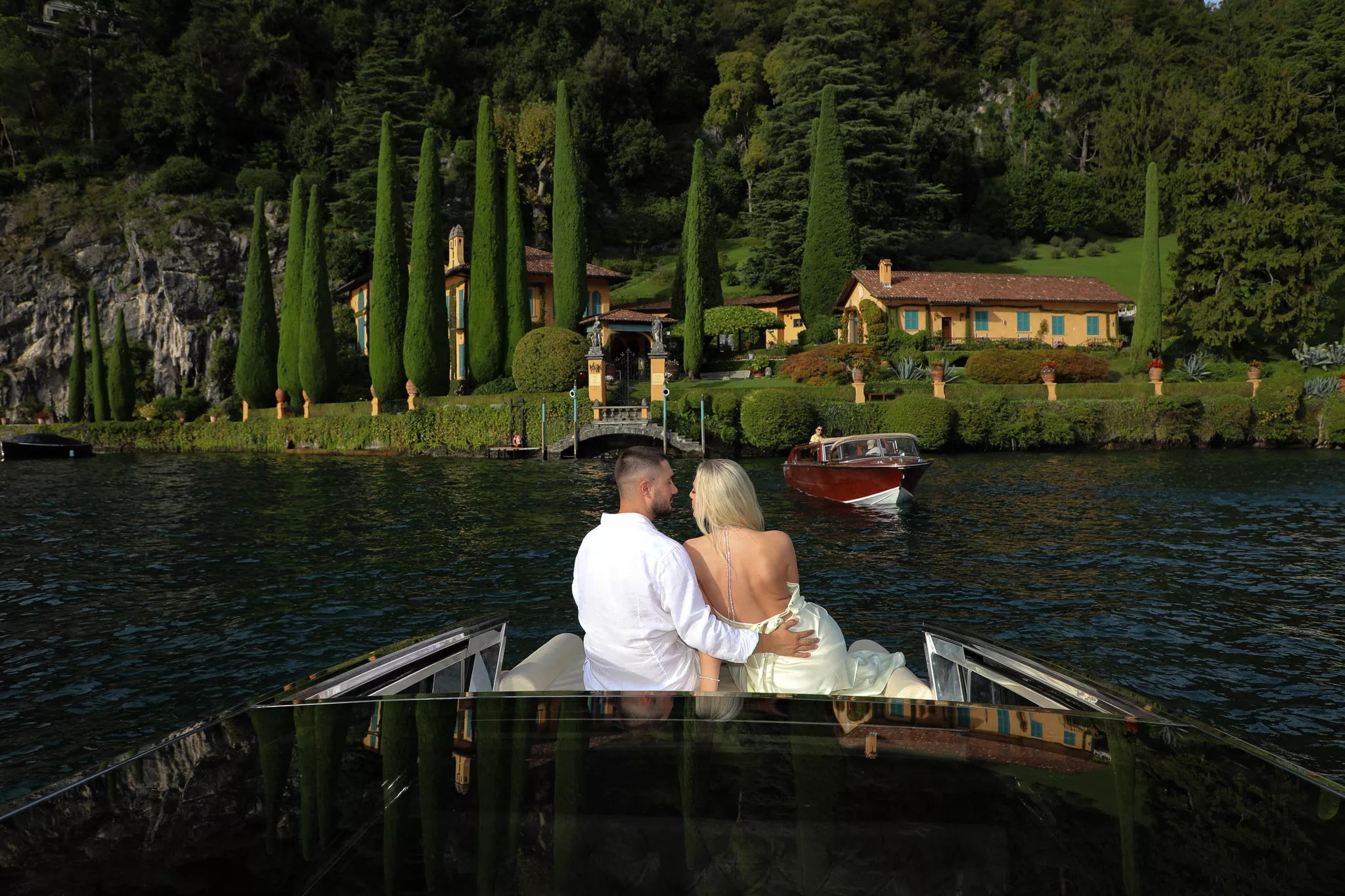Couple celebrating with champagne on a private boat after their Lake Como proposal
