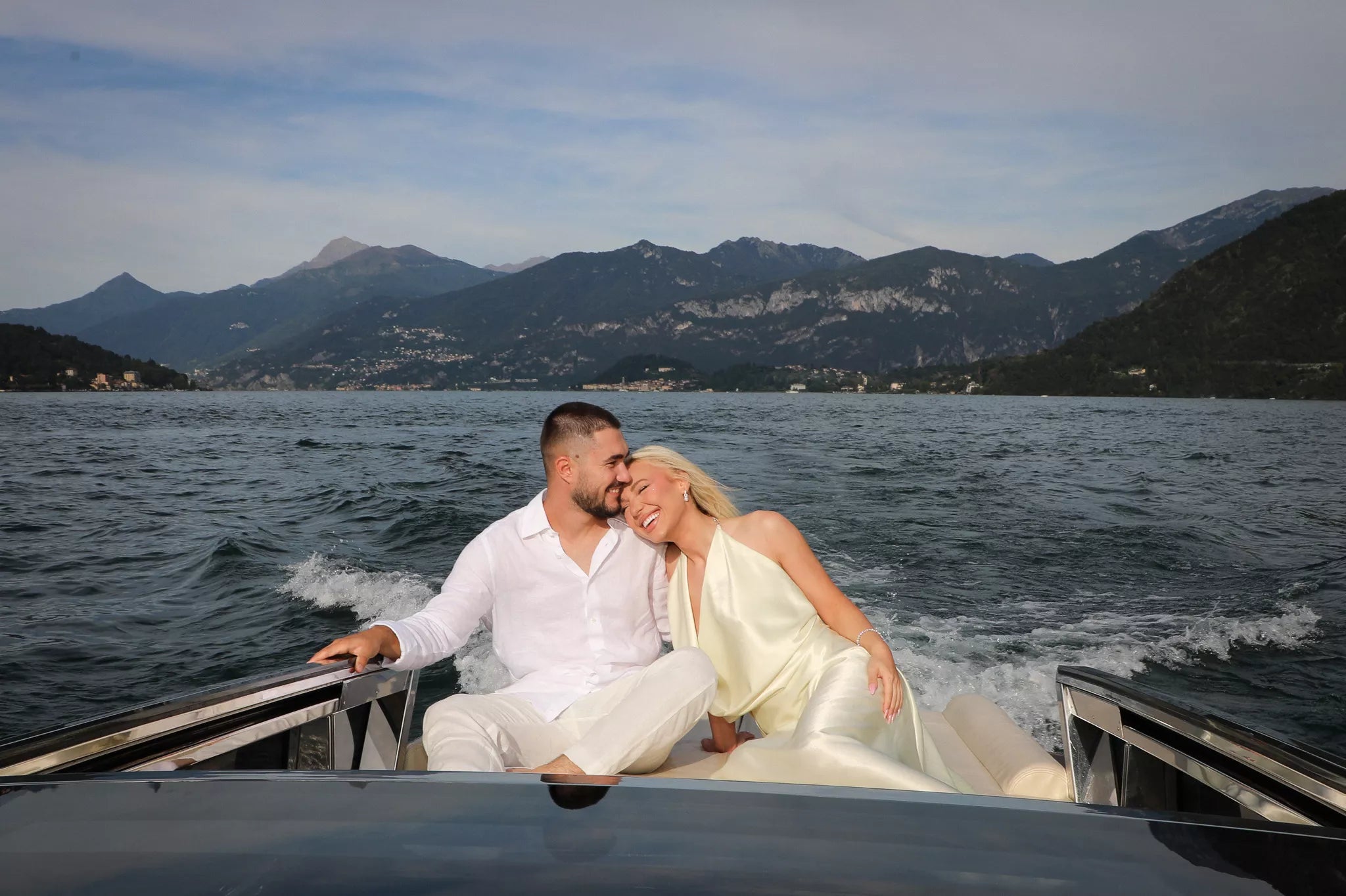 Scenic view of a private boat on Lake Como surrounded by mountains at sunset