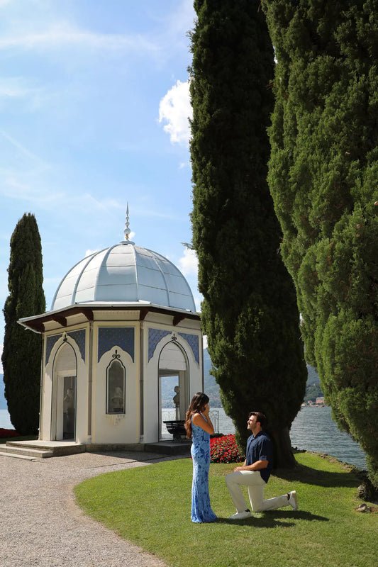 Romantic marriage proposal at Villa Melzi Gardens in Bellagio, Lake Como – man on one knee proposing by the iconic white gazebo with lake and cypress trees in the background.