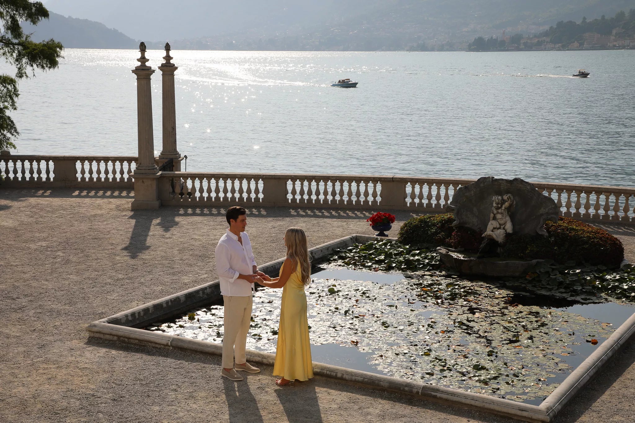 Lake Como proposal videographer filming a couple walking through Villa Melzi Gardens’ lakefront paths in Bellagio