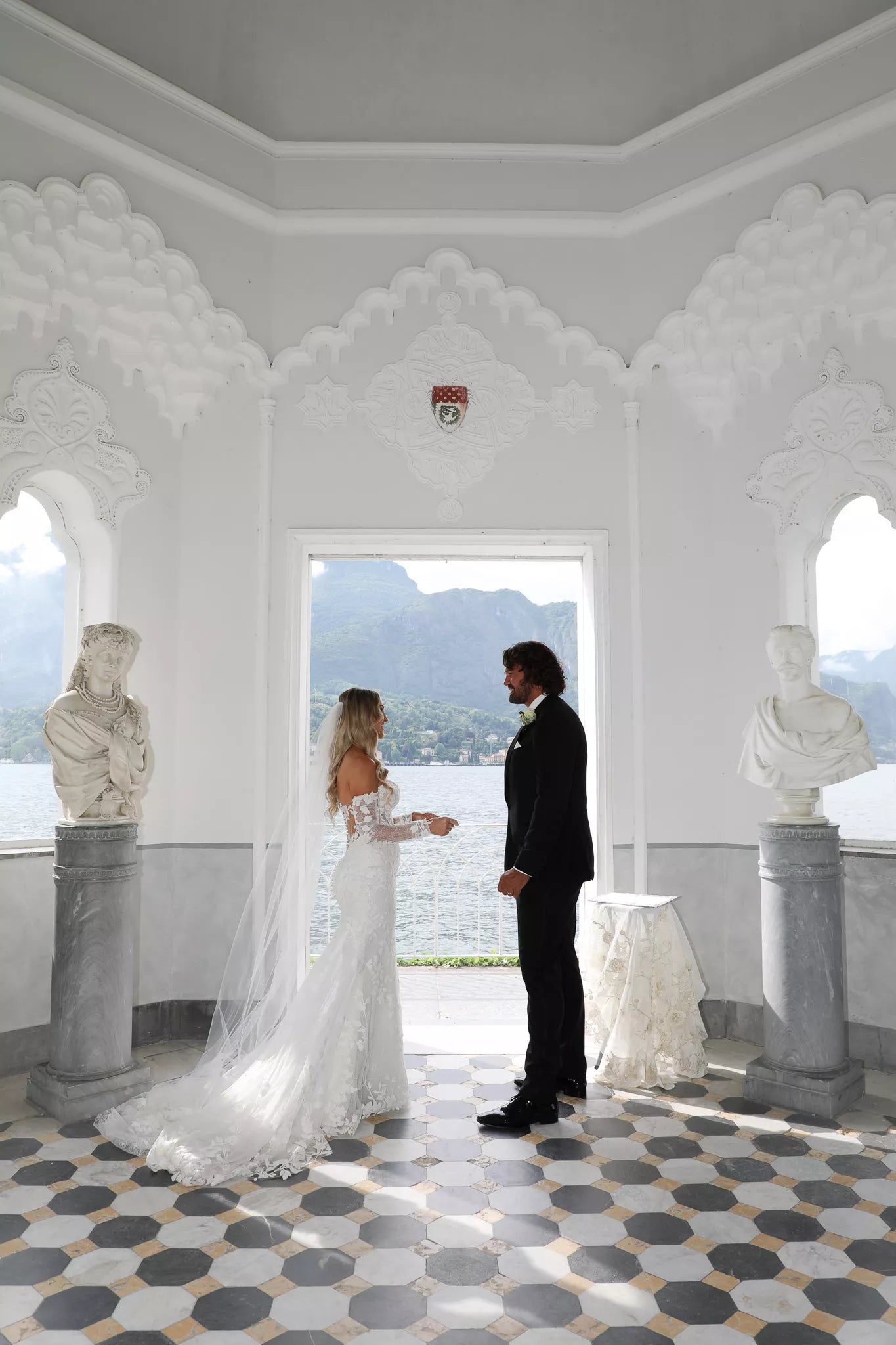Lake Como wedding photographer capturing an elegant bride and groom ceremony inside the white pavilion at Villa Melzi with lake and mountain views