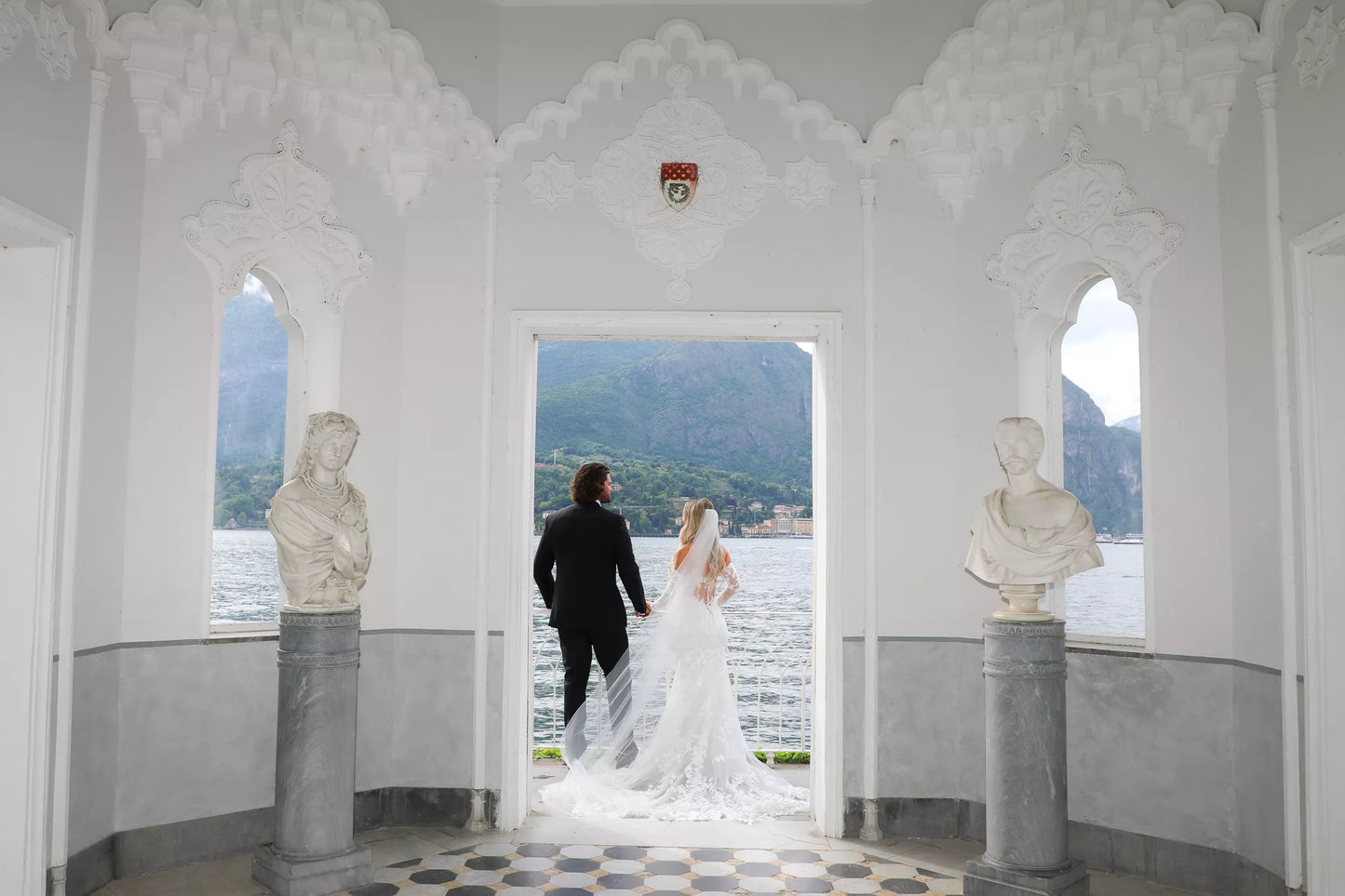Luxury Lake Como wedding photography of bride and groom standing in the Villa Melzi pavilion overlooking the lake