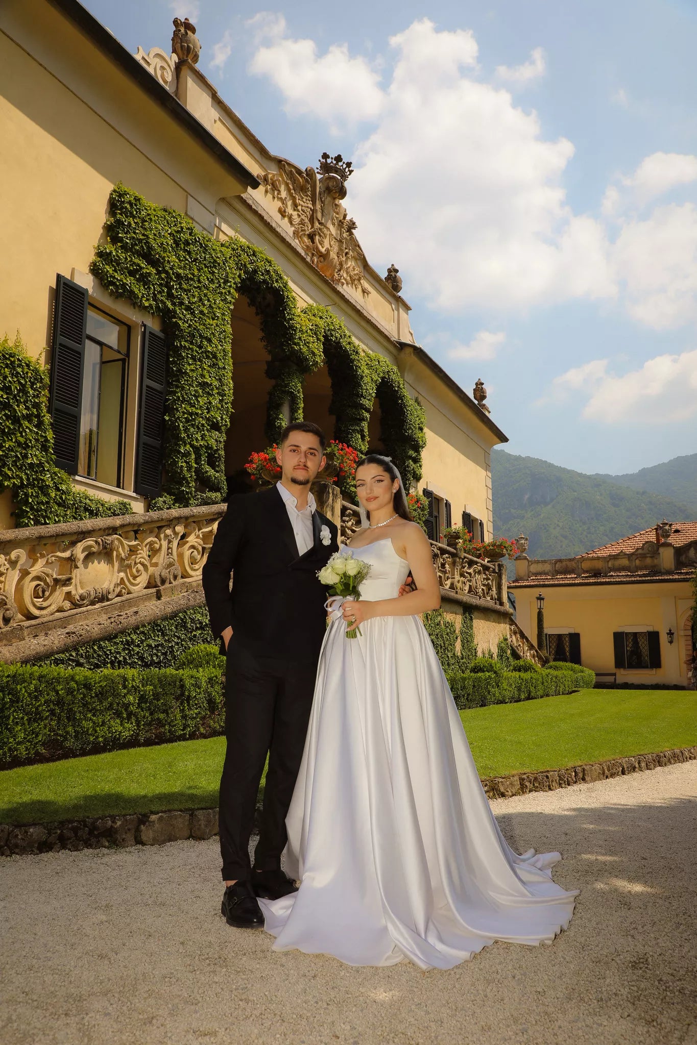 Bride and groom posing in front of Villa del Balbianello’s sunlit exterior during a luxury Lake Como wedding session