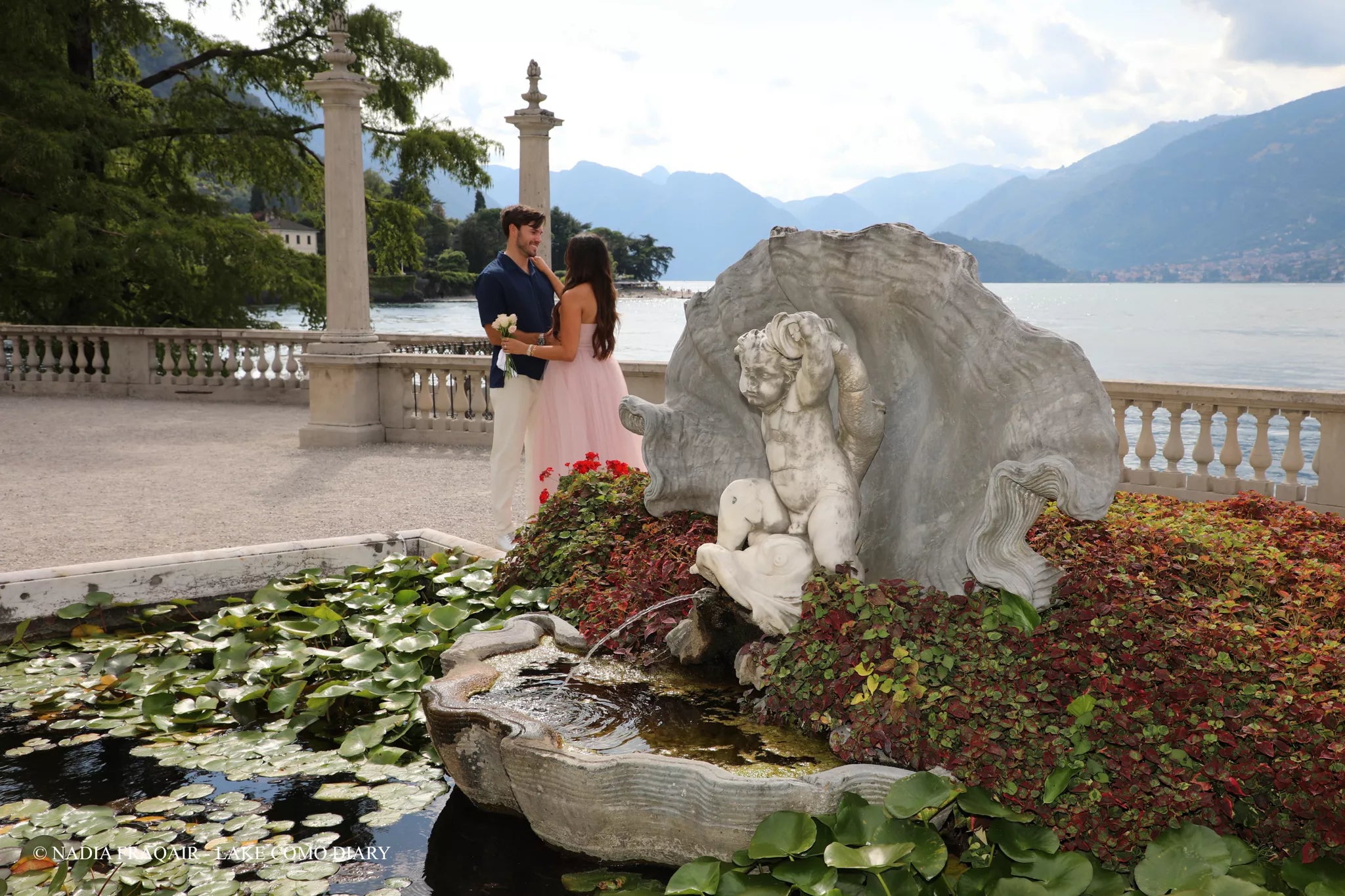 Couple walking along the lakefront path at Villa Melzi Gardens in Bellagio moments before a surprise proposal on Lake Como.