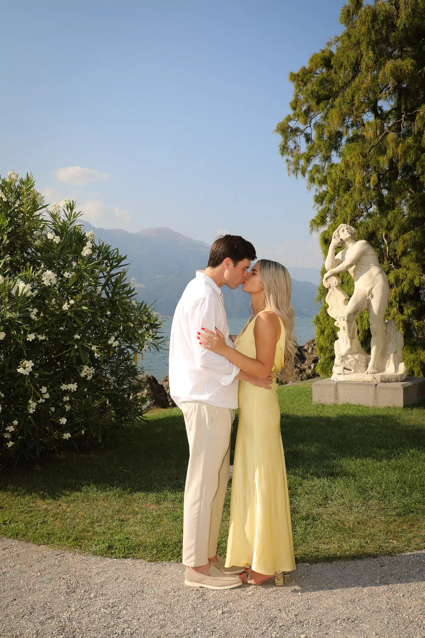 Historic sculptures and blooming flowers inside Villa Melzi Gardens in Bellagio, Lake Como.