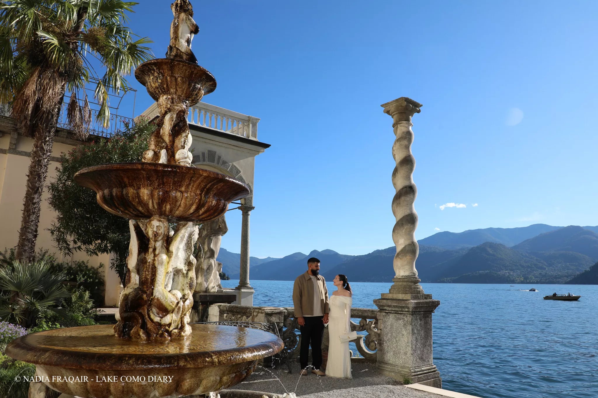 Romantic proposal photography at Villa Monastero in Varenna with a couple standing under garden arches overlooking Lake Como
